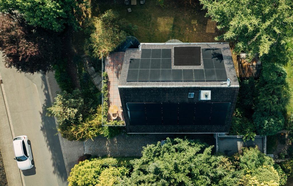 Wohnhaus von oben mit PVT-Modulen auf dem Dach - Waermequelle und Stromerzeugung auf derselben Flaeche