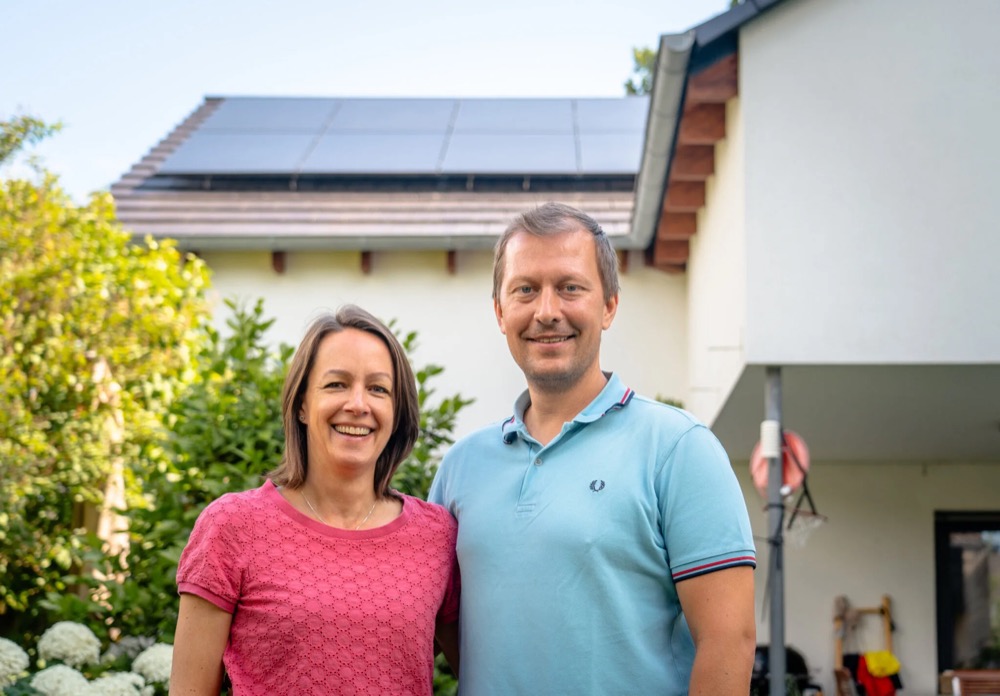 Ein Ehepaar vor seinem Haus mit PVT-Anlage - unabhaengig von Oel und Gas heizen
